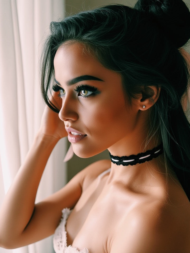 Woman with dark hair styled in an updo, wearing a Chantilly black lace choker, in a softly lit indoor setting.