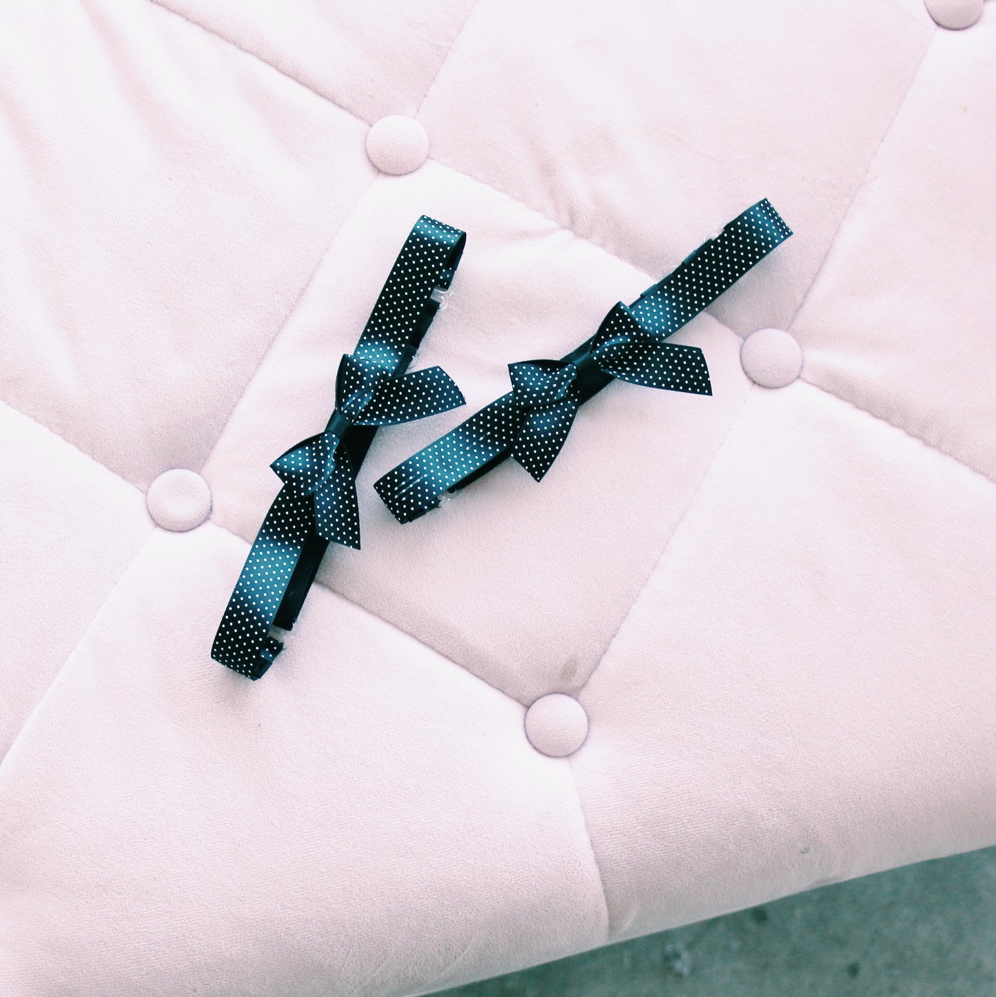 two black pinup bow leg garters on pink elegant chair