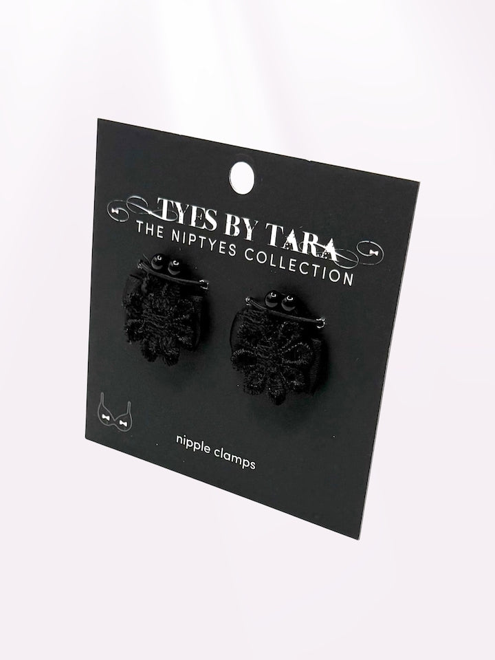 Black flower nipple clamps jewelry on a 'Tyes by Tara' branded card against a white background