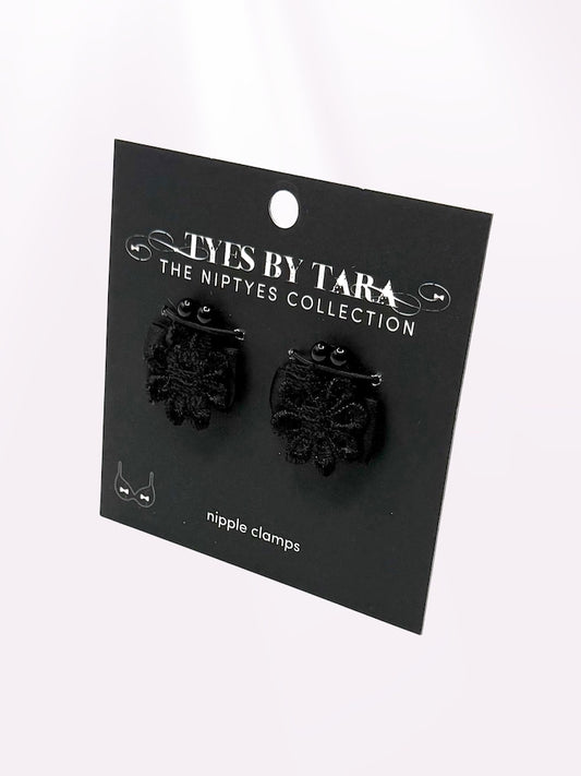 Black flower nipple clamps jewelry on a 'Tyes by Tara' branded card against a white background