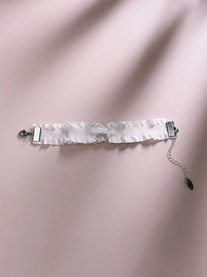 White Ruffled White Bracelet on Pink Background