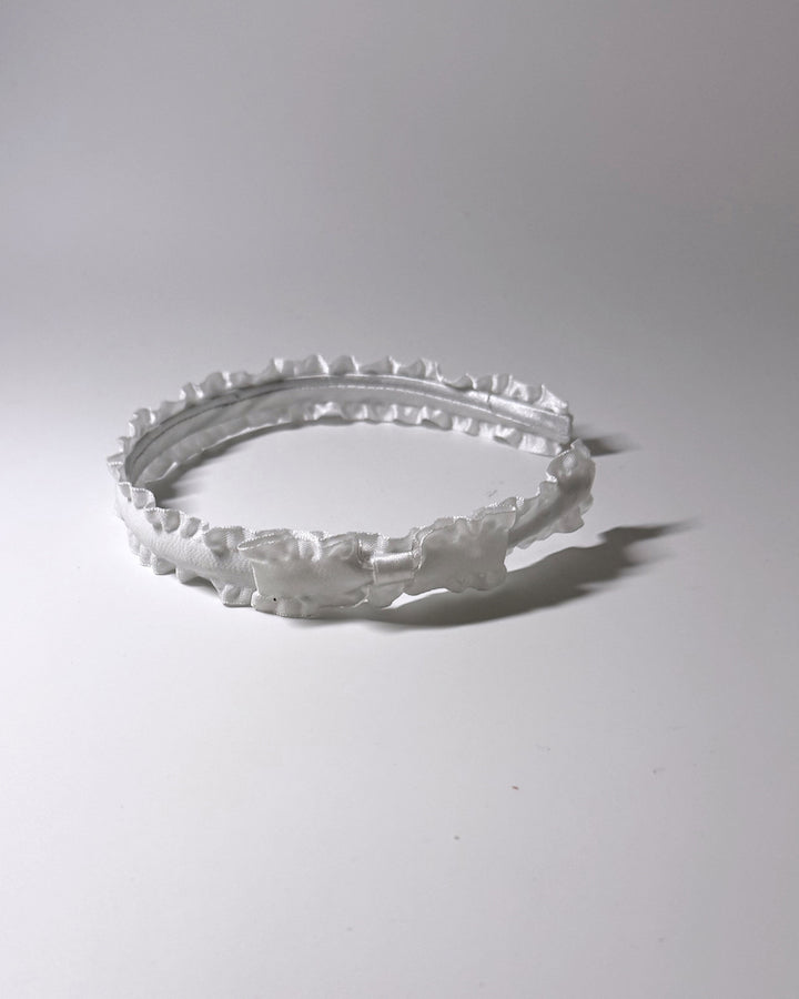 White Ruffled Bow Headband with side bow on light gray background