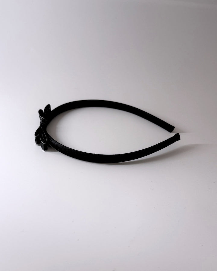 Black Bow Headband with black bow on top of crown side view