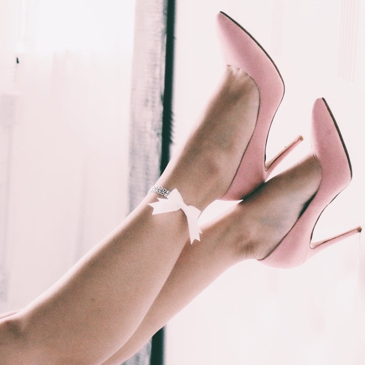 white sparkly bow anklet on model with pink heels in white boudor