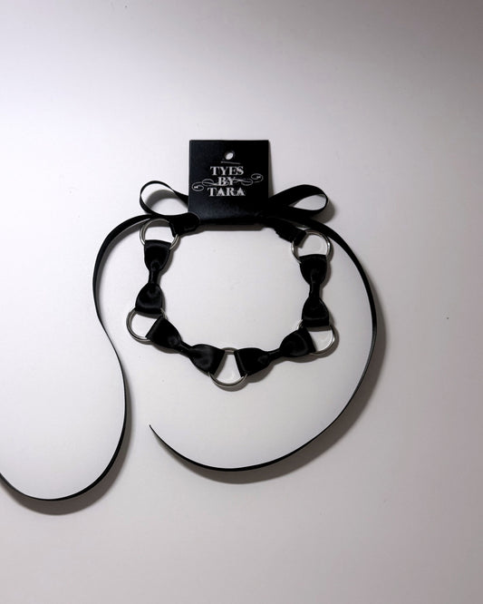 Runaway Bow Headband with retail tag attached on softly lit background