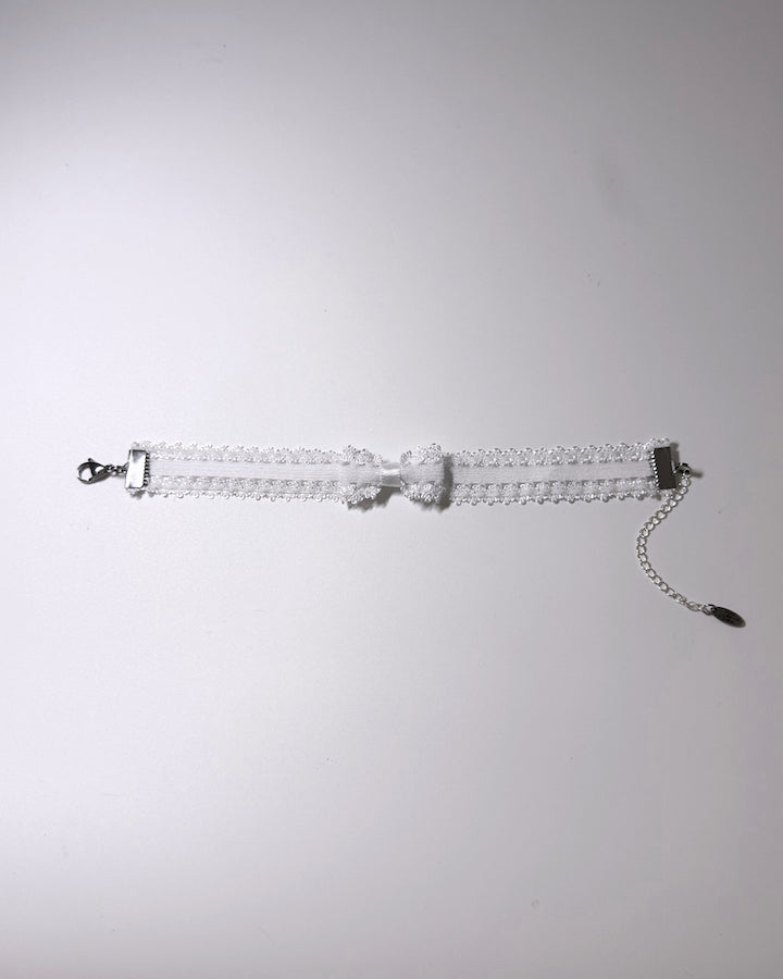 Lady White Elastic Bow Anklet flatlay on softly lit background
