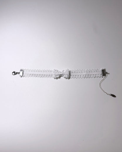 Lady White Elastic Bow Anklet flatlay on softly lit background