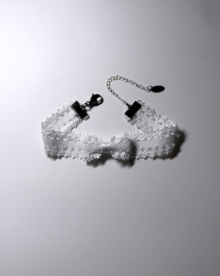 Lady White Elastic Bow Anklet on softly lit background