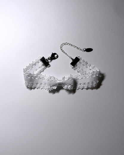 Lady White Elastic Bow Anklet on softly lit background
