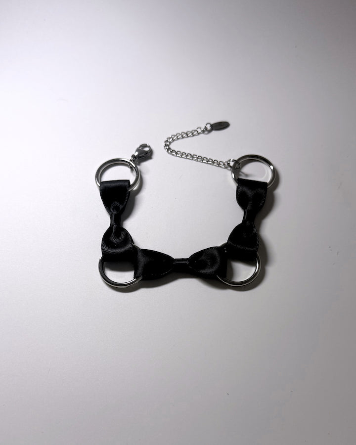 runaway black bow bracelet on softly lit surface