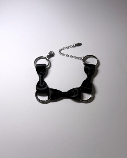 runaway black bow bracelet on softly lit surface
