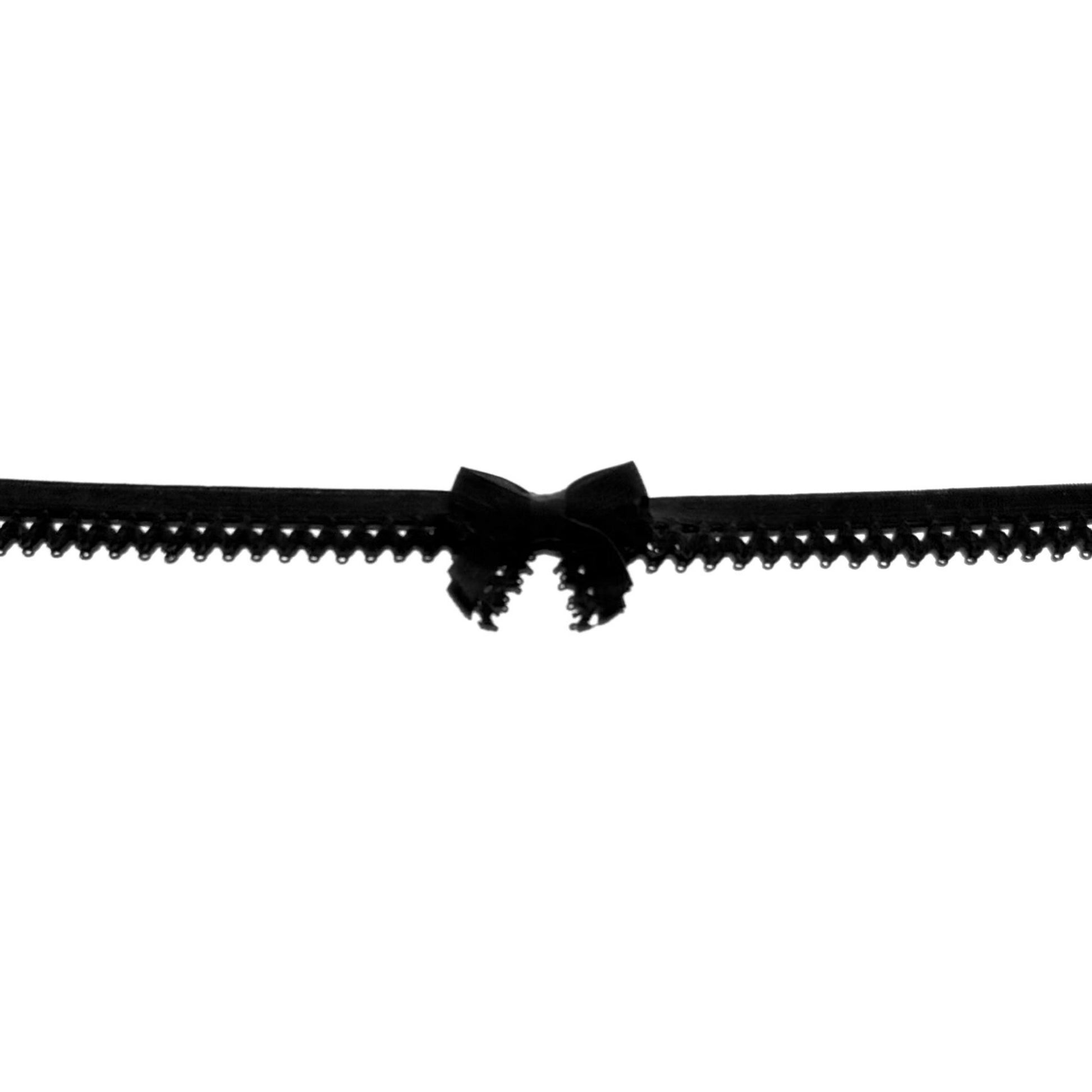 Black elastic belt with a bow on a white background close up view