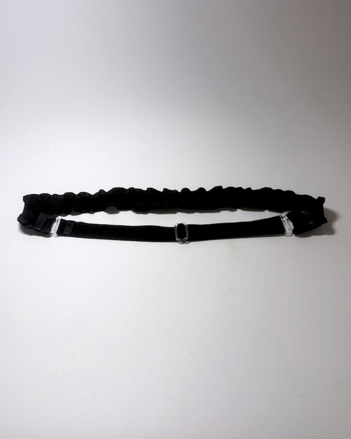 Black Ruffled Bow Belt on softly lit surface showing the elastic adjustable strap