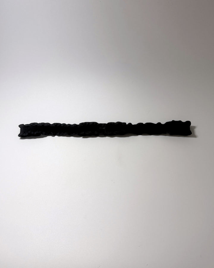 Black Ruffled Bow Belt on softly lit surface