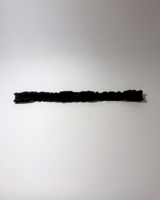 Black Ruffled Bow Belt on softly lit surface