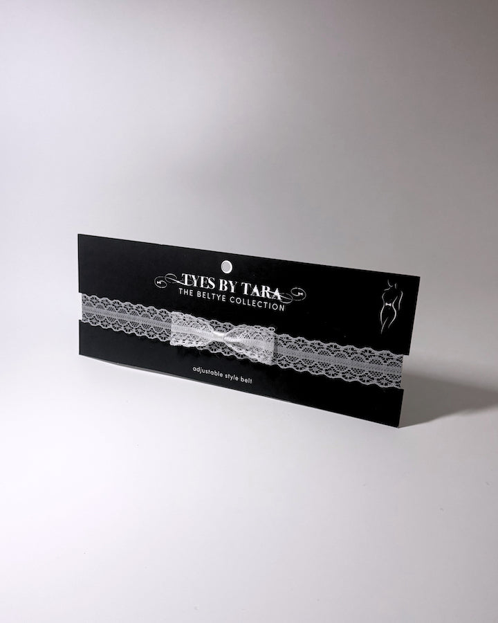 Siren White Lace Bow Bridal Belt on light gray surface black card