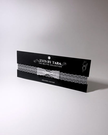 Siren White Lace Bow Bridal Belt on light gray surface black card