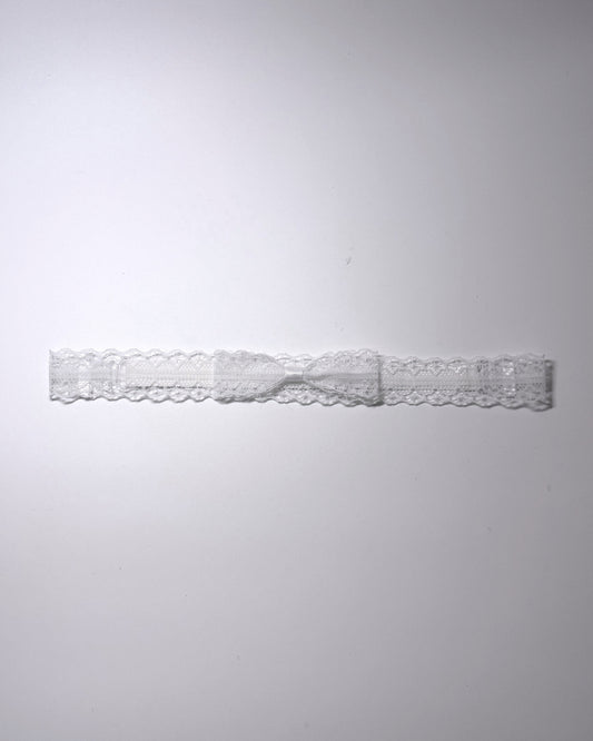 Siren White Lace Bow Bridal Belt on light gray surface