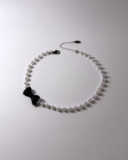 Centerfold Pearl Bow Necklace with black bow off to the side 