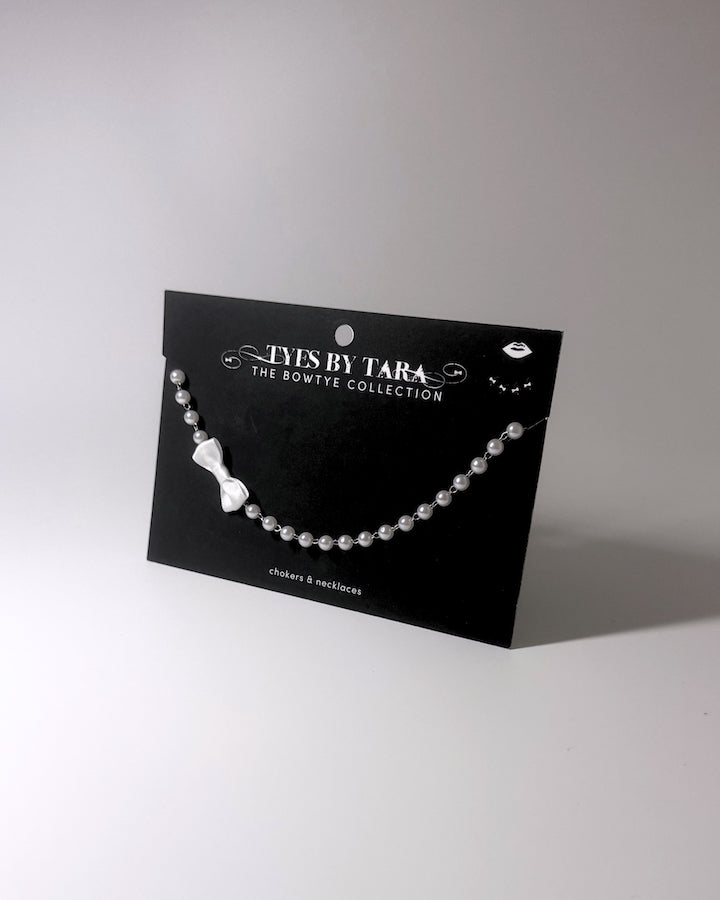 Centerfold White Pearl Bow Necklace on Black Card
