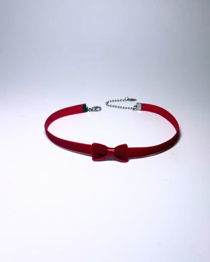 Red Velvet Bow Choker on softly lit surface