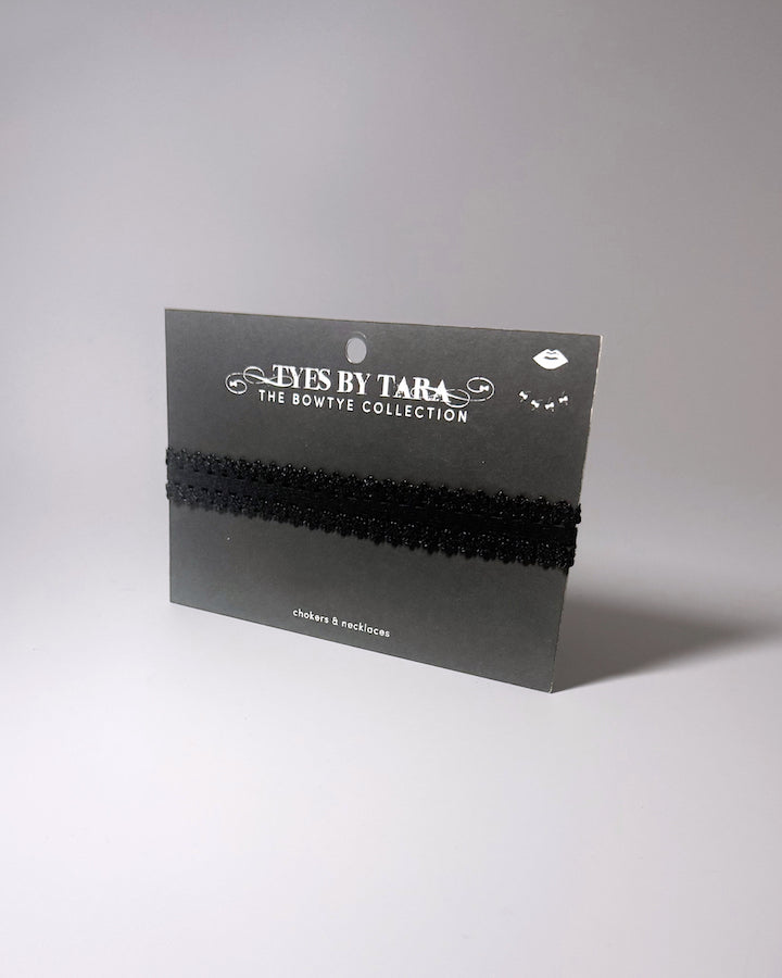 Black Elastic bow choker on light gray background displayed on black retail card