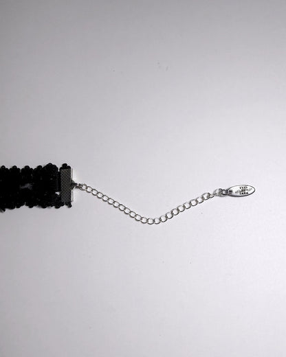 Black Elastic bow choker on light gray background showing logo tag