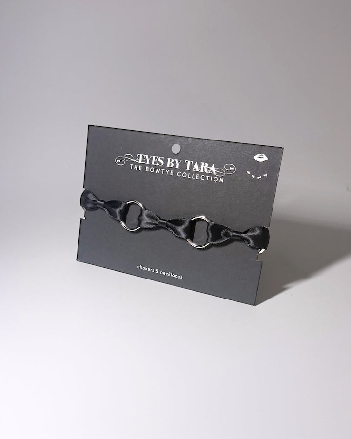 Runaway black o ring bow choker displayed on black retail card