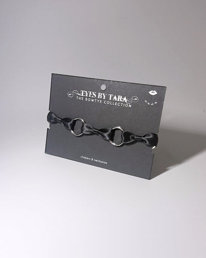 Runaway black o ring bow choker displayed on black retail card