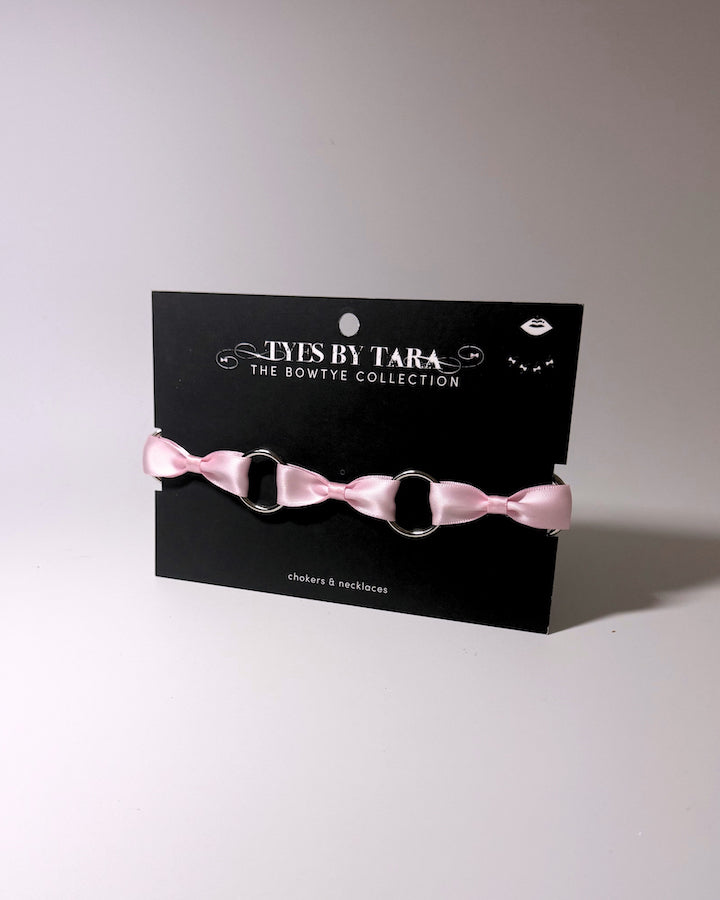 Runaway pink bow choker on black card