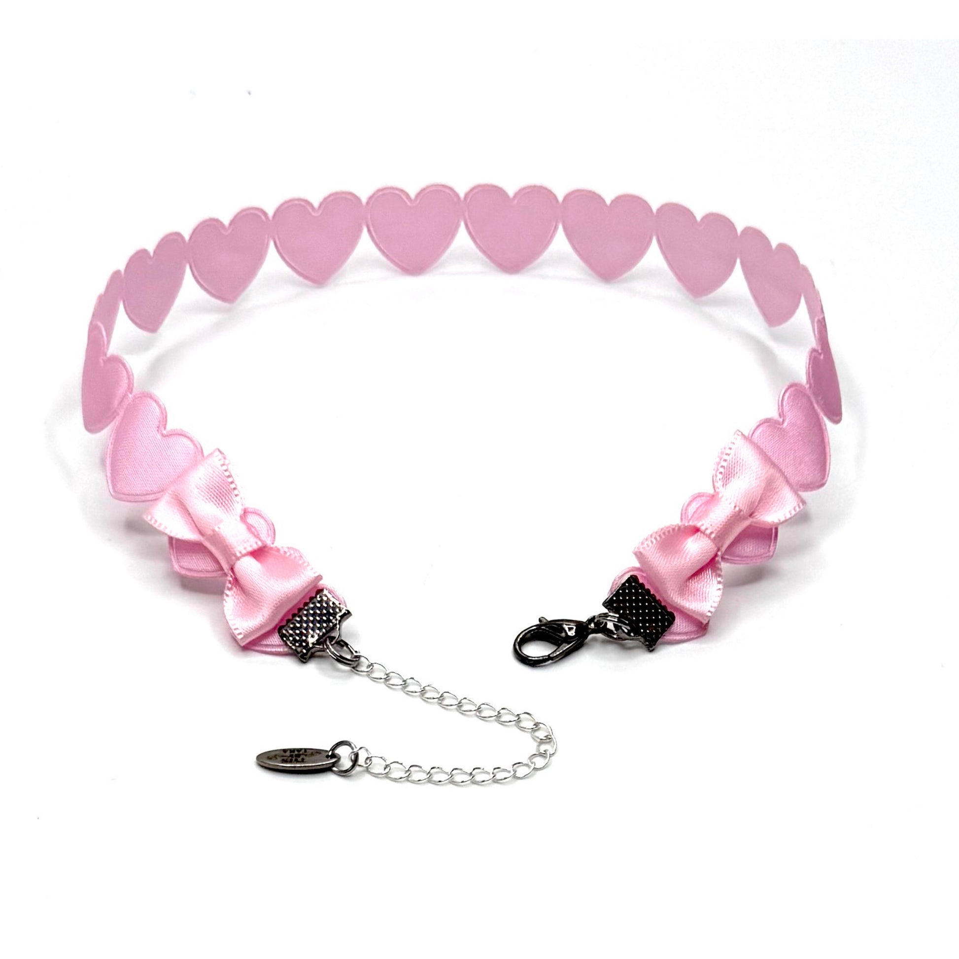 Pink heart-shaped choker with bows and chain on a white background