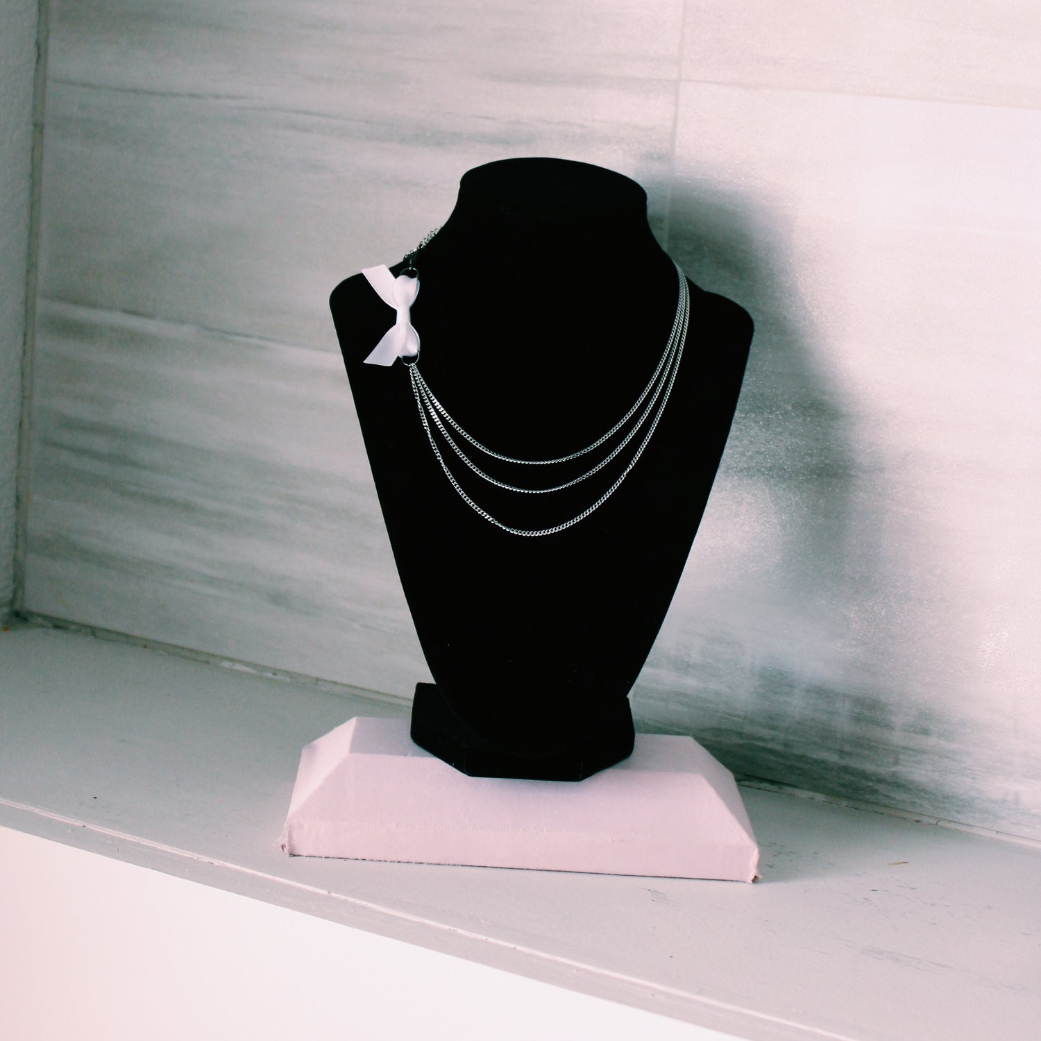 vice white bow necklace on black neck form 