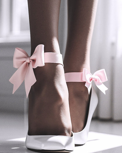 Model wearing pink bow heel straps with white heels