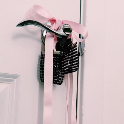 Black Sparkly Handcuffs with Long Pink Satin Ties on Door Knob