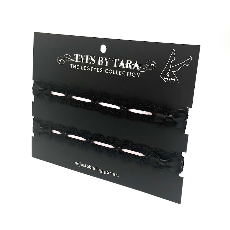 Black adjustable black lace leg garters on a 'Tyes by Tara' branded card.