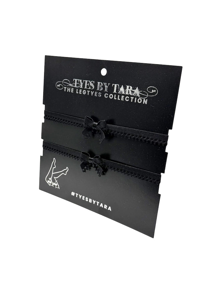 Black Foxy Lingerie Leg Garters on a 'Eyes by Tara' branded card with a white background