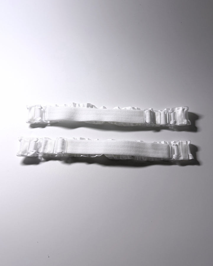White Ruffled Bow Leg Garters displayed on light gray showing the elastic adjustable straps background with soft shadows