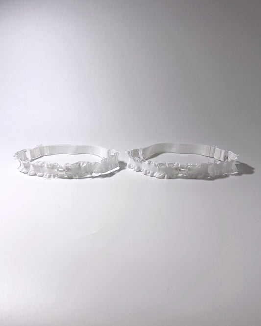 White Ruffled Bow Leg Garters displayed on light gray background with soft shadows