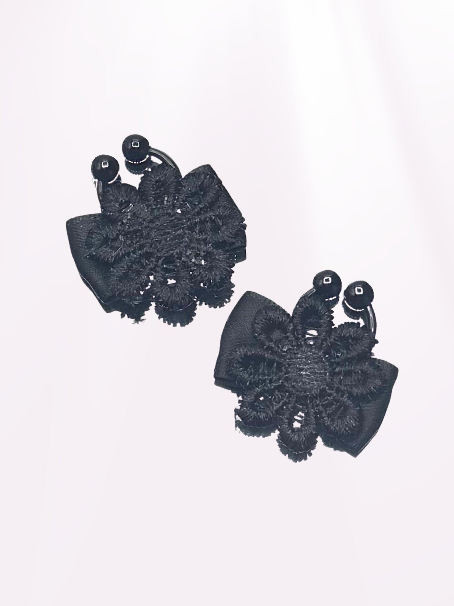 black flower nipple jewelry clamps on light pink background