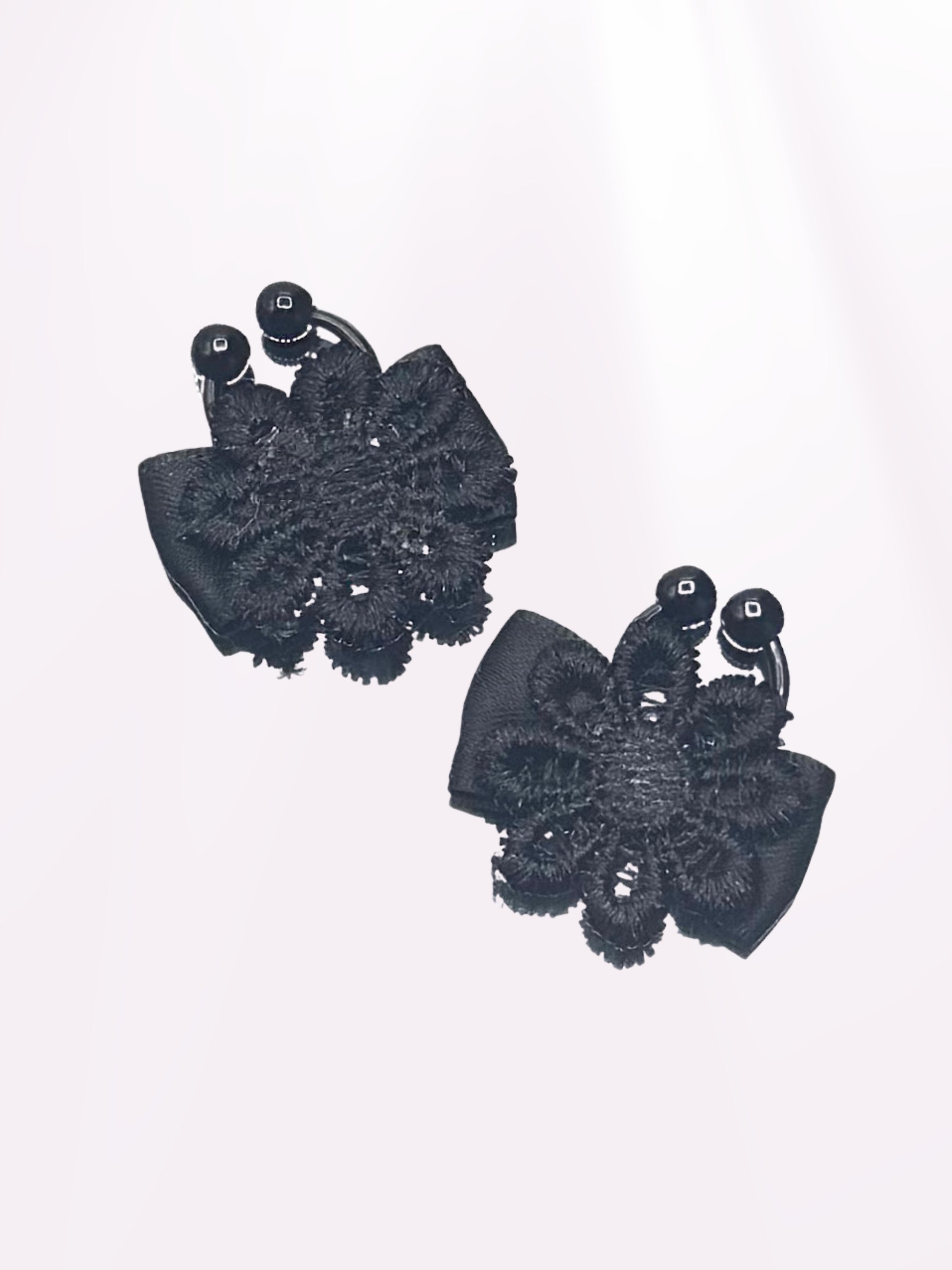 black flower nipple jewelry clamps on light pink background