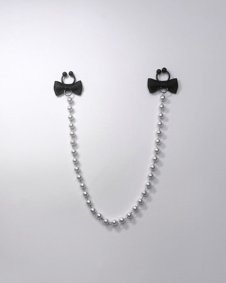 Centerfold Pearl Nipple Clamps with black bows and a creamy pearl strand connecting them