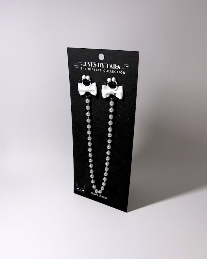 the white bow pearl nipple clamps on black card