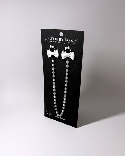 the white bow pearl nipple clamps on black card