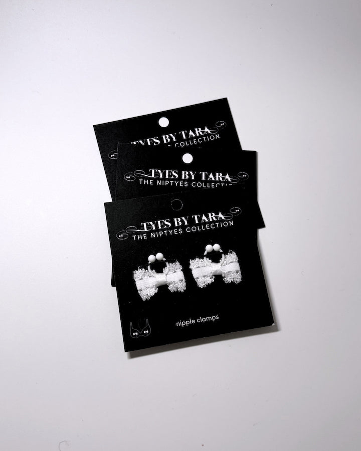 Lady White bow nipple jewelry clamps on black cards