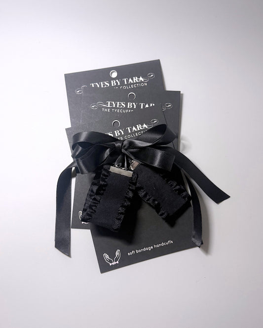 Black Ruffled Handcuffs with long satin ties shown as a 3 pack