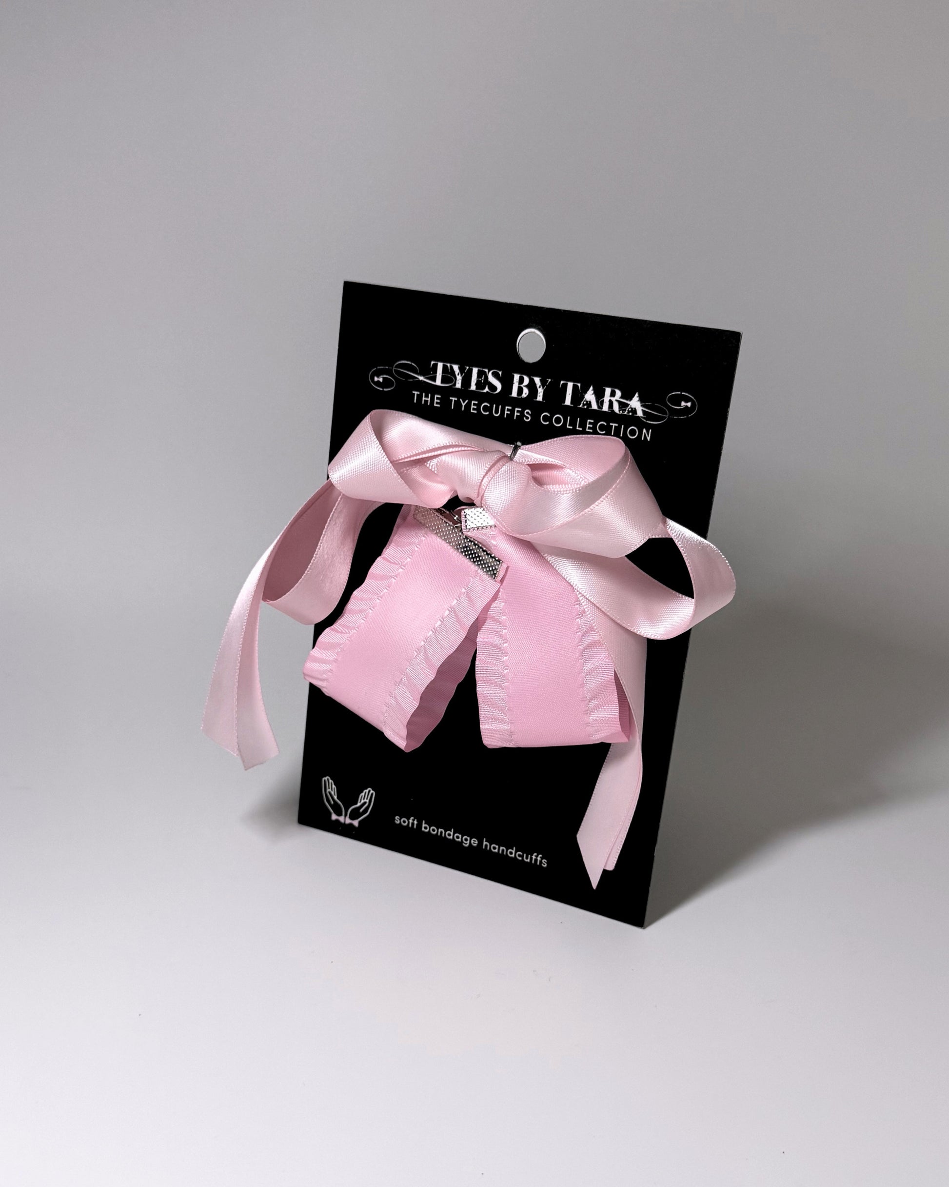 Pink Ruffled Handcuffs with long satin ties on black card