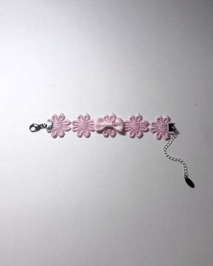 Pink Flower Bow Bracelet on softly lit background laid flat showing the stainless steel extender chain