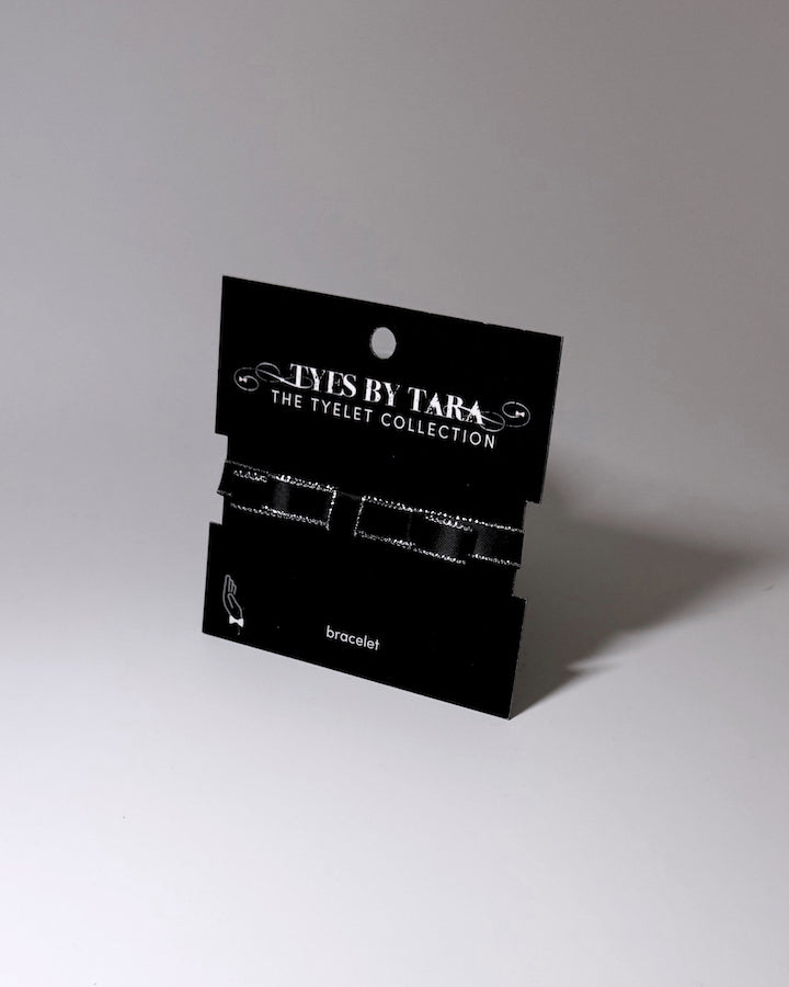 queen black bow metallic trimmed bracelet on black card