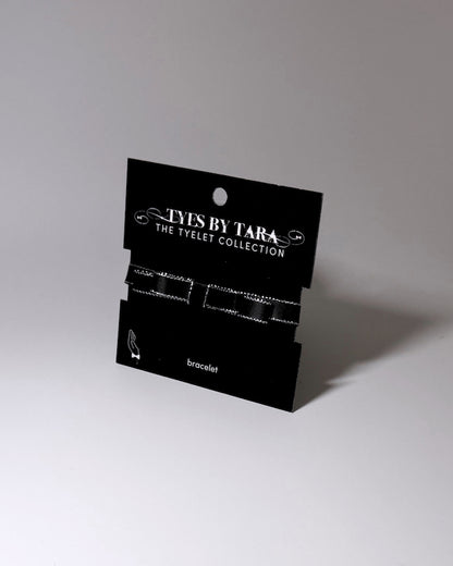 queen black bow metallic trimmed bracelet on black card