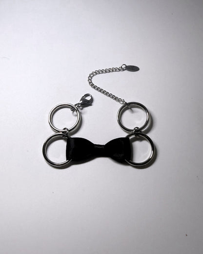 Black Bow Bracelet with Stainless Steel Loops on a softly lit background